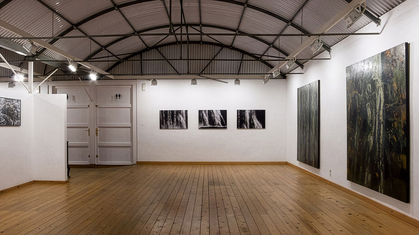 Espacio de exposición con obras de arte grandes y medianas en exhibición.