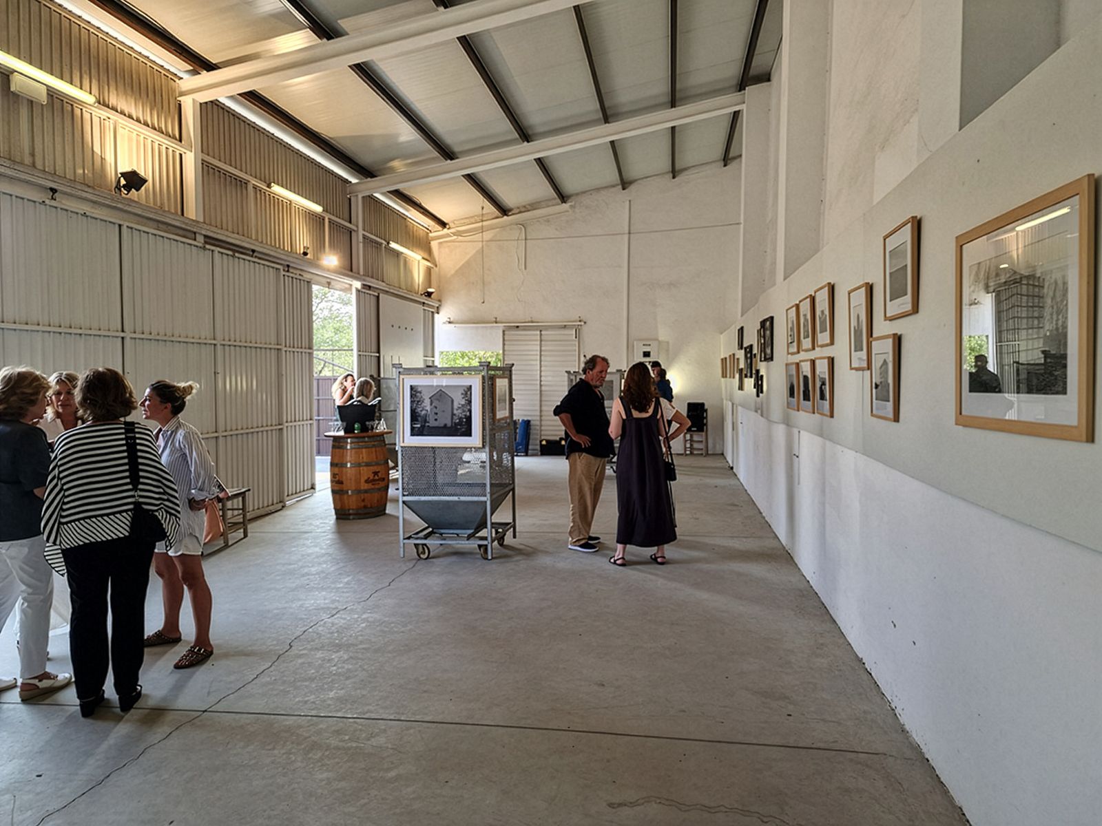 Visitantes discutiendo obras de arte en una galería minimalista de estilo industrial.